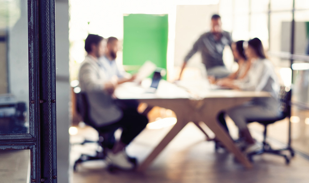 Blurred photo of people at a conference table