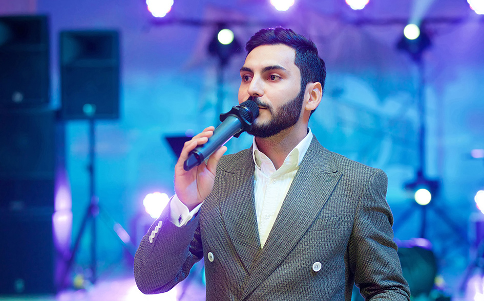 Speaker talking into a microphone on stage